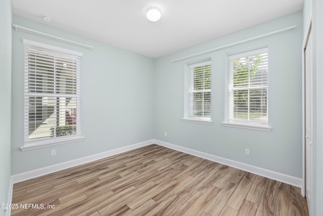 unfurnished room featuring baseboards and light wood-type flooring