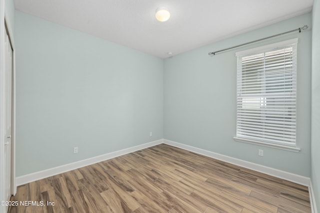 empty room with baseboards and wood finished floors