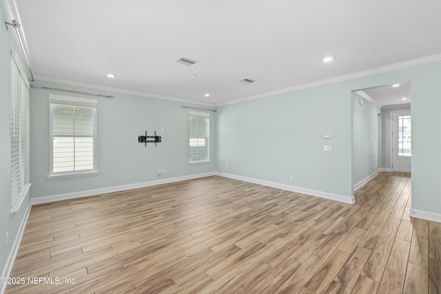 empty room with ornamental molding, a healthy amount of sunlight, and light wood-style floors