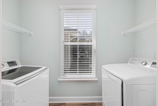clothes washing area featuring washing machine and clothes dryer, laundry area, and baseboards