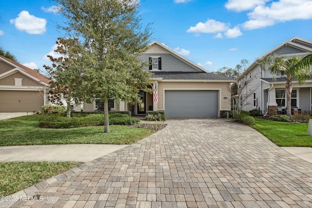 85325 Champlain Dr, Fernandina Beach, FL 32034 - craftsman house with decorative driveway, a garage, and a front lawn