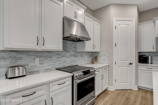 85325 Champlain Dr, Fernandina Beach, FL 32034 - kitchen featuring under cabinet range hood, electric stove, white cabinets, light wood-style floors, and decorative backsplash
