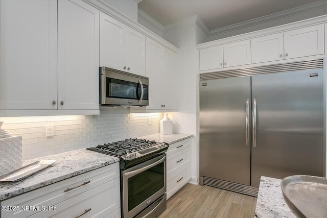 109 Rimini Ct, Jacksonville, FL 32225 - kitchen with appliances with stainless steel finishes, ornamental molding, white cabinets, light wood finished floors, and light stone countertops