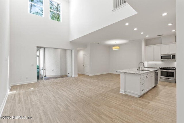 109 Rimini Ct, Jacksonville, FL 32225 - kitchen featuring appliances with stainless steel finishes, a sink, white cabinets, light wood finished floors, and baseboards