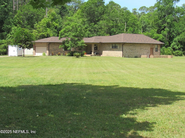 view of front of house with brick siding, a garage, and a front lawn