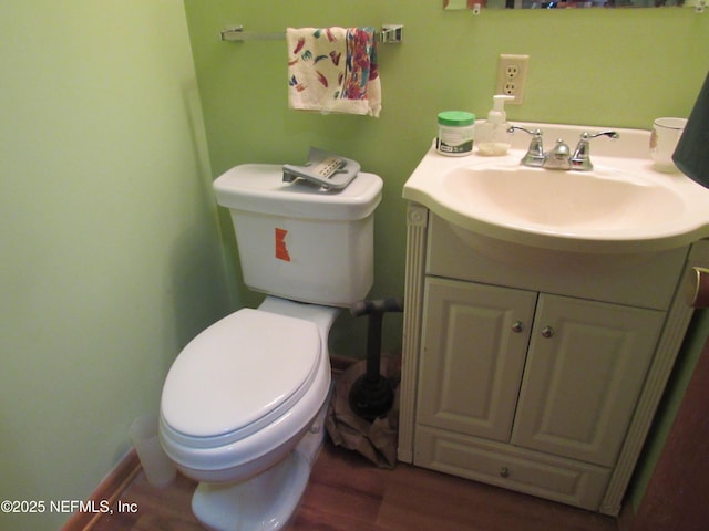 half bath with vanity, toilet, and wood finished floors