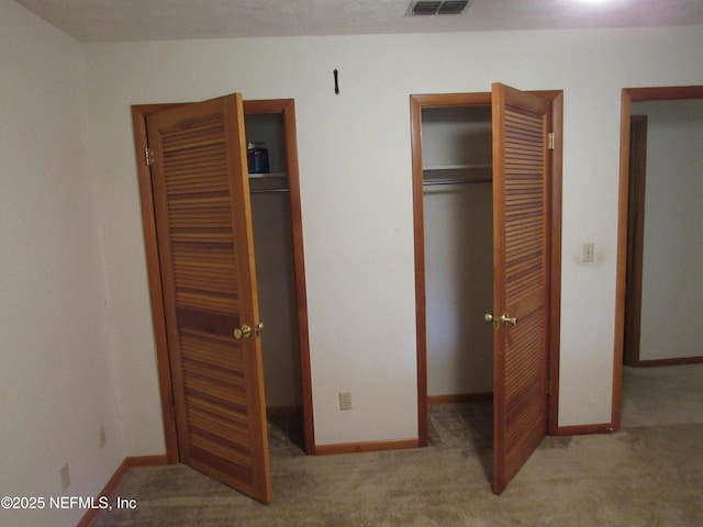 unfurnished bedroom featuring carpet floors, baseboards, and visible vents