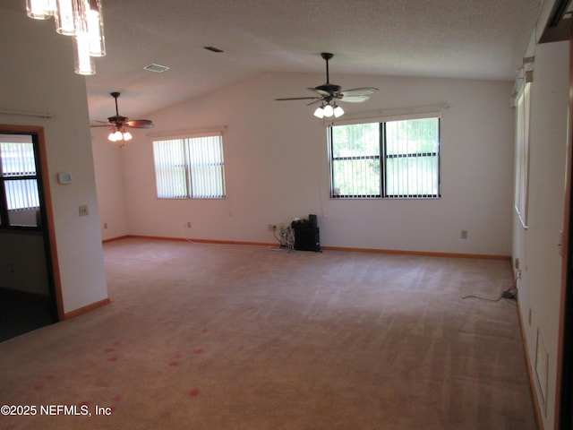 spare room featuring light colored carpet, baseboards, ceiling fan, and vaulted ceiling