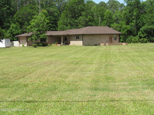 ranch-style house featuring brick siding, a garage, and a front yard