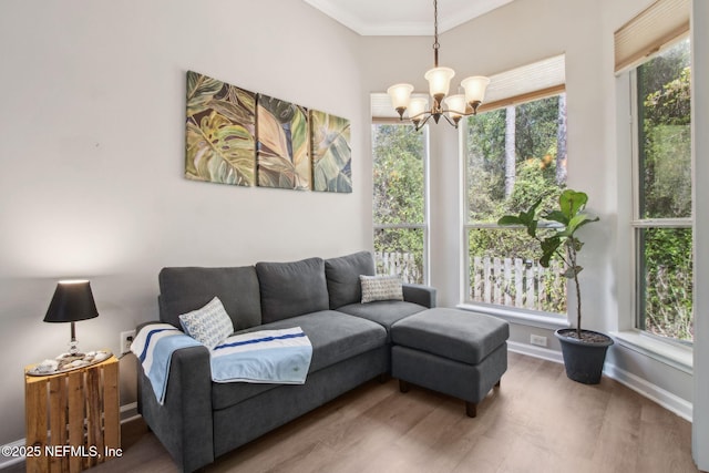 living room featuring a chandelier, wood finished floors, ornamental molding, and baseboards