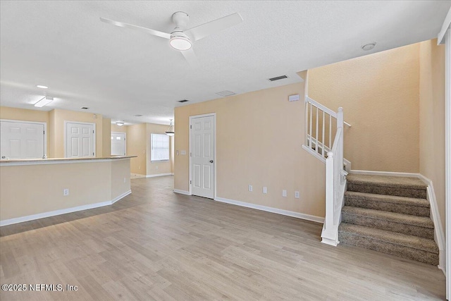 8550 Argyle Business Loop Unit 407, Jacksonville, FL 32244 - unfurnished living room featuring light wood-style floors, stairway, a ceiling fan, and baseboards