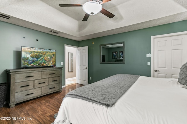 bedroom with visible vents, a ceiling fan, and dark wood-style floors