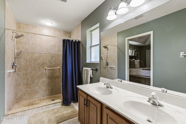 ensuite bathroom featuring visible vents, a sink, connected bathroom, and a tile shower