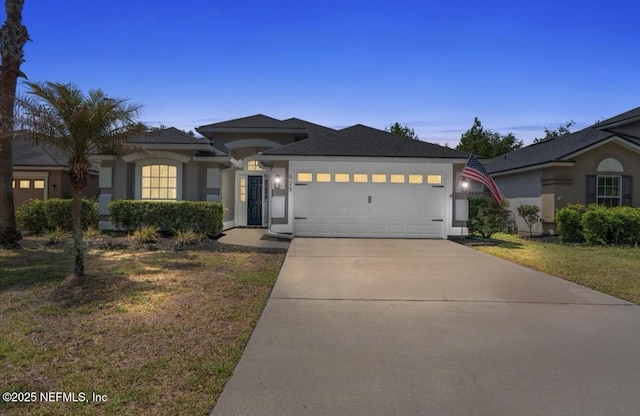 view of front of property featuring concrete driveway, a garage, a yard, and stucco siding