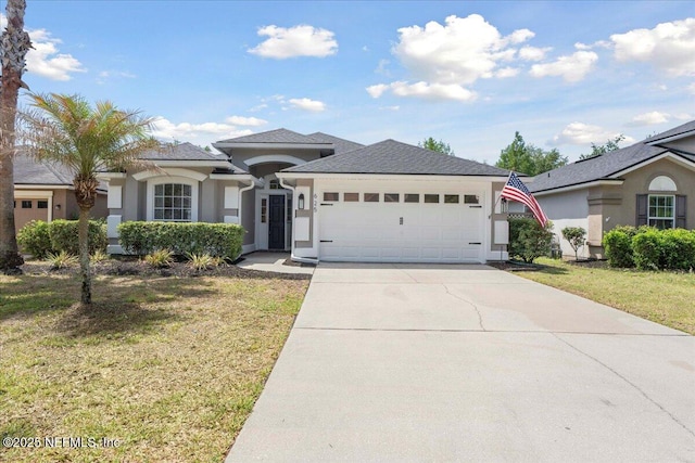 view of front of home featuring concrete driveway, a garage, a front lawn, and stucco siding
