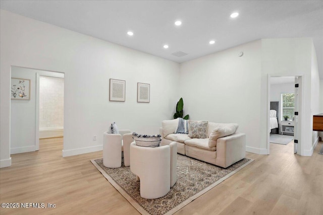 living room featuring recessed lighting, baseboards, visible vents, and light wood-style floors