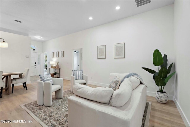 living room with recessed lighting, baseboards, visible vents, and light wood finished floors