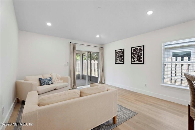 living room with recessed lighting, baseboards, and light wood-style floors