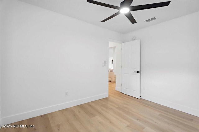 unfurnished room featuring a ceiling fan, baseboards, visible vents, and light wood-type flooring