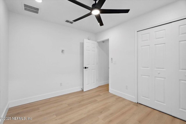 unfurnished bedroom featuring baseboards, visible vents, ceiling fan, and light wood-style floors