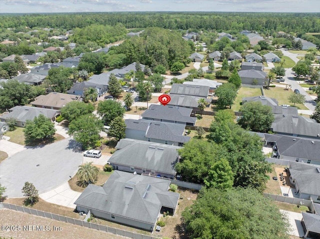 drone / aerial view featuring a residential view and a view of trees