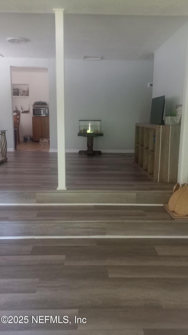 interior space with baseboards and wood finished floors