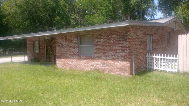view of side of property with a yard and brick siding