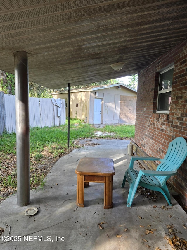 565 Starratt Rd, Jacksonville, FL 32218 - view of patio featuring fence and an outbuilding