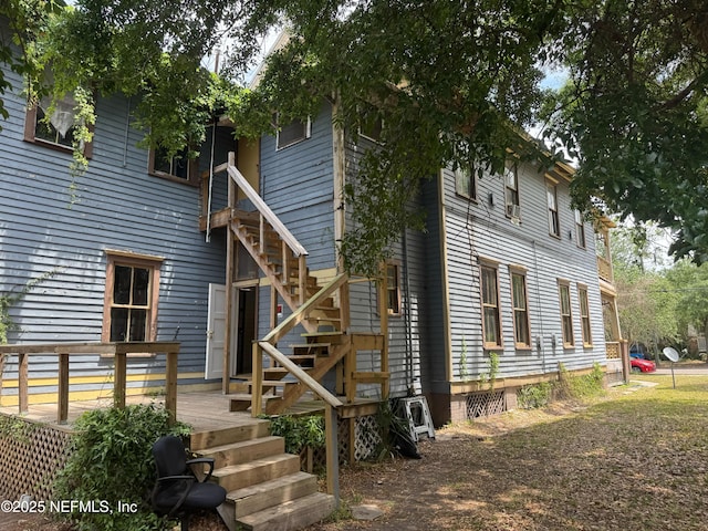 view of home's exterior featuring stairway and a wooden deck
