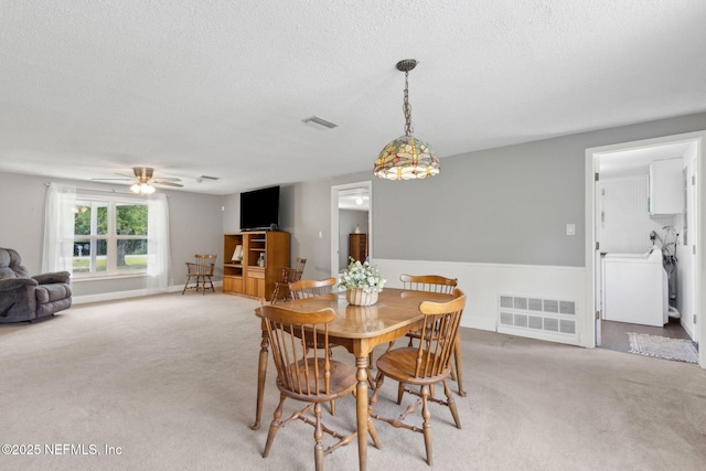 dining area featuring visible vents, a textured ceiling, and light carpet