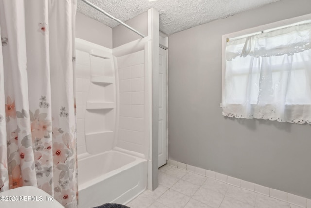 bathroom with tile patterned flooring, toilet, baseboards, a textured ceiling, and shower / bath combo
