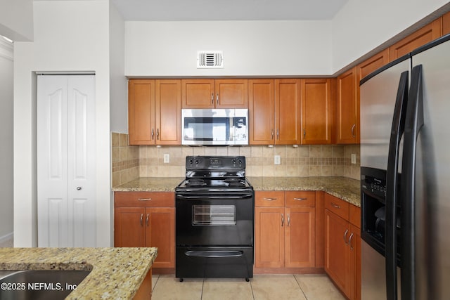 kitchen featuring brown cabinetry, stainless steel appliances, and visible vents