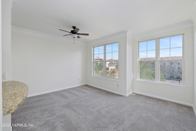 unfurnished room featuring baseboards, ornamental molding, carpet, and a ceiling fan