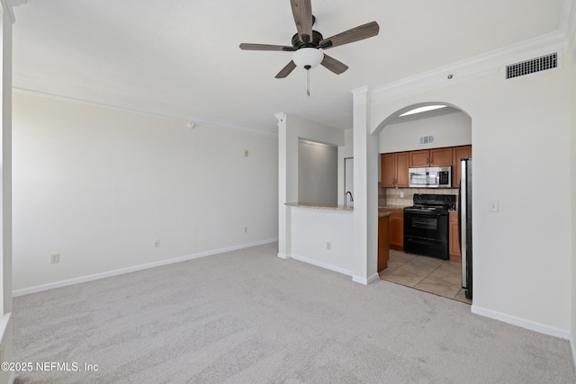 unfurnished living room with a ceiling fan, light colored carpet, crown molding, arched walkways, and visible vents