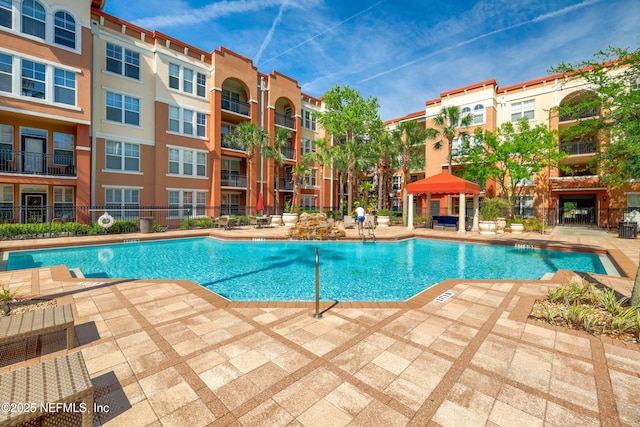 community pool with a patio and a gazebo