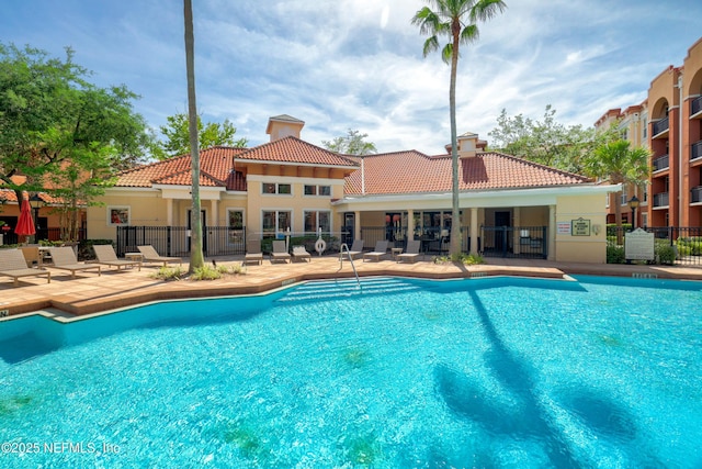 pool with fence and a patio