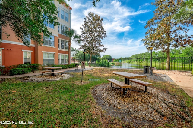 view of property's community featuring fence and a yard