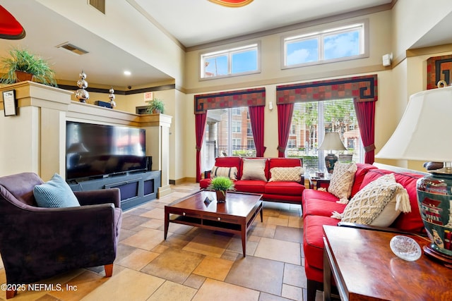 living area with visible vents, a high ceiling, and stone tile flooring