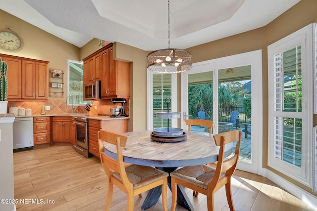 3626 Kapalua Ct, Green Cove Springs, FL 32043 - dining area with a tray ceiling, light wood-type flooring, and a chandelier