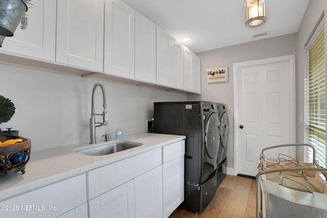 3626 Kapalua Ct, Green Cove Springs, FL 32043 - washroom with cabinet space, a sink, wood finished floors, visible vents, and washing machine and dryer