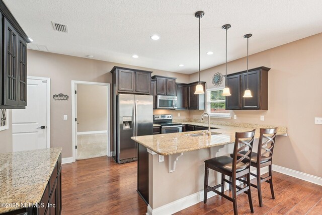 2968 Ravine Hill Dr, Middleburg, FL 32068 - kitchen featuring stainless steel appliances, dark wood-style floors, a sink, light stone countertops, and baseboards