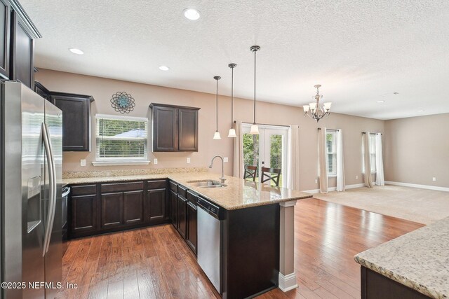 2968 Ravine Hill Dr, Middleburg, FL 32068 - kitchen with appliances with stainless steel finishes, a sink, a peninsula, open floor plan, and a chandelier
