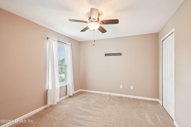 2968 Ravine Hill Dr, Middleburg, FL 32068 - empty room featuring light colored carpet, a ceiling fan, baseboards, and a textured ceiling