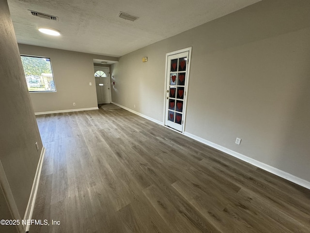 5612 Oliver St, Jacksonville, FL 32211 - unfurnished living room with visible vents, dark wood-style flooring, and baseboards