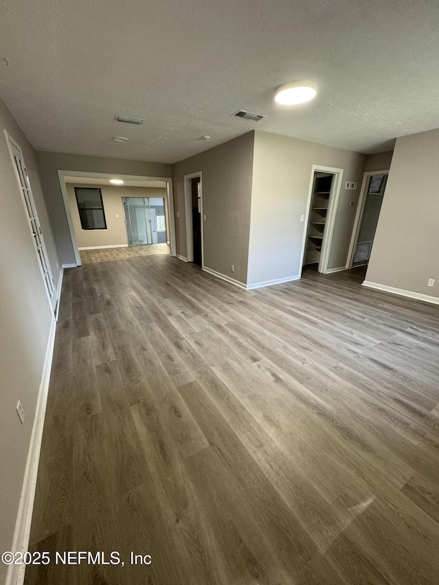 5612 Oliver St, Jacksonville, FL 32211 - unfurnished living room with a textured ceiling, visible vents, wood finished floors, and baseboards