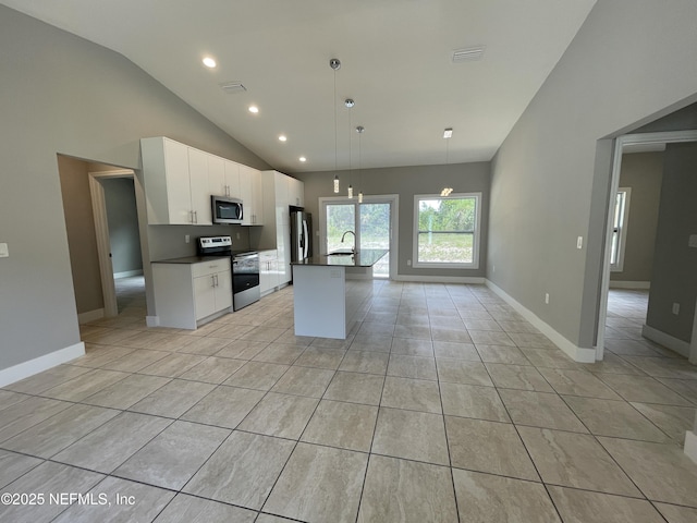 kitchen with dark countertops, appliances with stainless steel finishes, a sink, recessed lighting, and light tile patterned floors