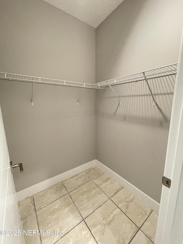 walk in closet featuring light tile patterned flooring