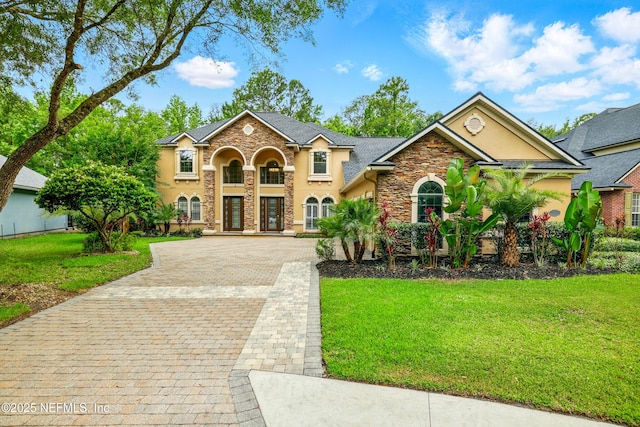 725 Carthage Pl, Saint Johns, FL 32259 - view of front of house featuring stucco siding, stone siding, decorative driveway, and a front yard