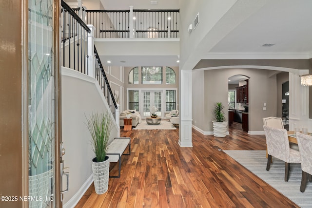 725 Carthage Pl, Saint Johns, FL 32259 - foyer entrance with arched walkways, healthy amount of natural light, wood finished floors, a high ceiling, and ornamental molding