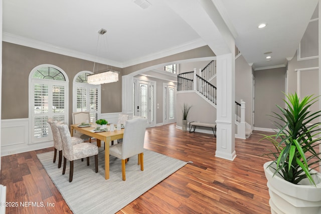 725 Carthage Pl, Saint Johns, FL 32259 - dining area featuring arched walkways, wood finished floors, a decorative wall, crown molding, and stairway